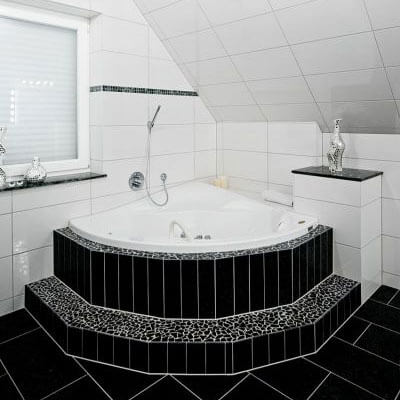Frisch saniertes Bad mit schöner Eckbadewanne auf einem Podest.
